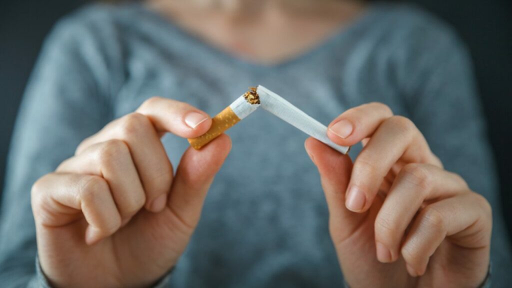 A Close Up Of The Hands Of A Woman Wearing A Blue Top Snapping A Cigarette In Half 1280x720