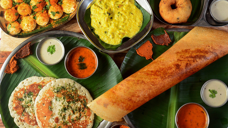 Assorted South Indian Breakfast Foods On Wooden Background. Ghee Dosa, Uttappam,medhu Vada,pongal,podi Idly And Chutney.. Dishes And Appetizers Of Indian Cuisine